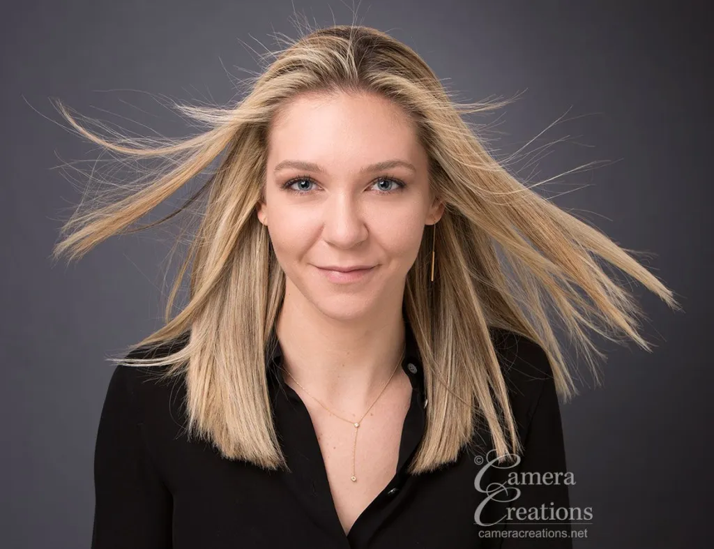 Fun professional headshot with hair blowing.